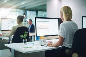 Generische Officeszene: Frau sitzt vor Bildschirm